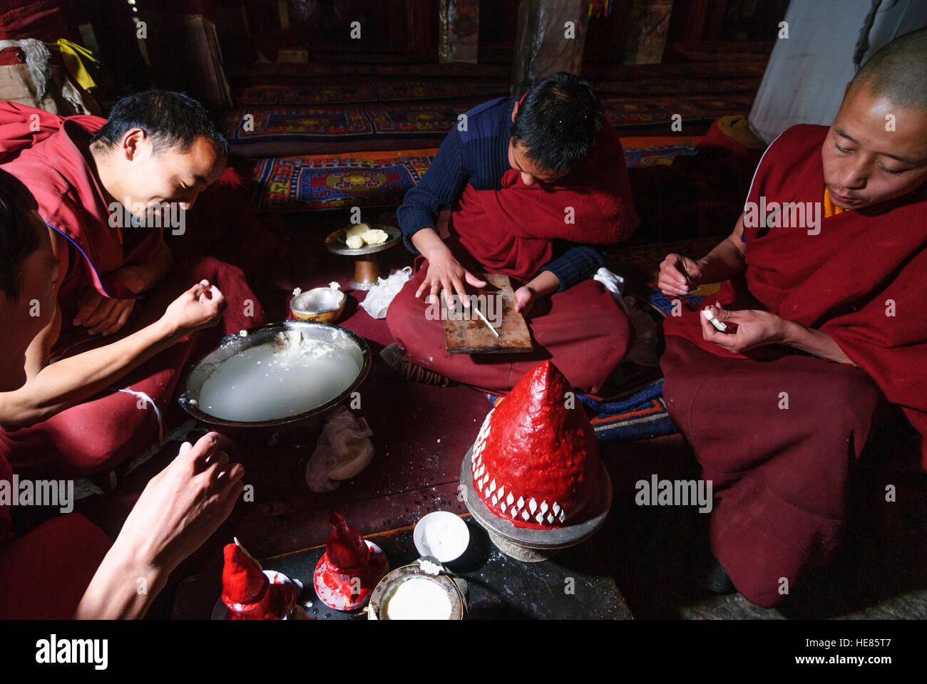 Lhasa: Monastery Drepung; Main Assembly Hall Tshogchen Dukhang; Monks make a Torma (sacrificial cake) with glaze. The sacrificial cakes are symbolical Stock Photo