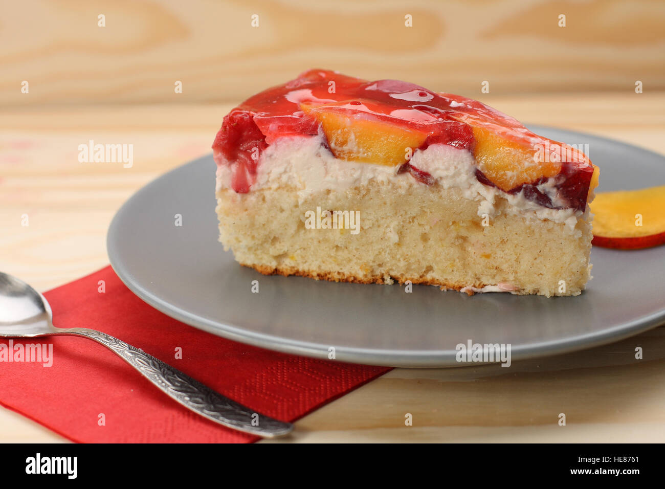 Strawberry and peach cake with gelatin on grey plate on wooden table