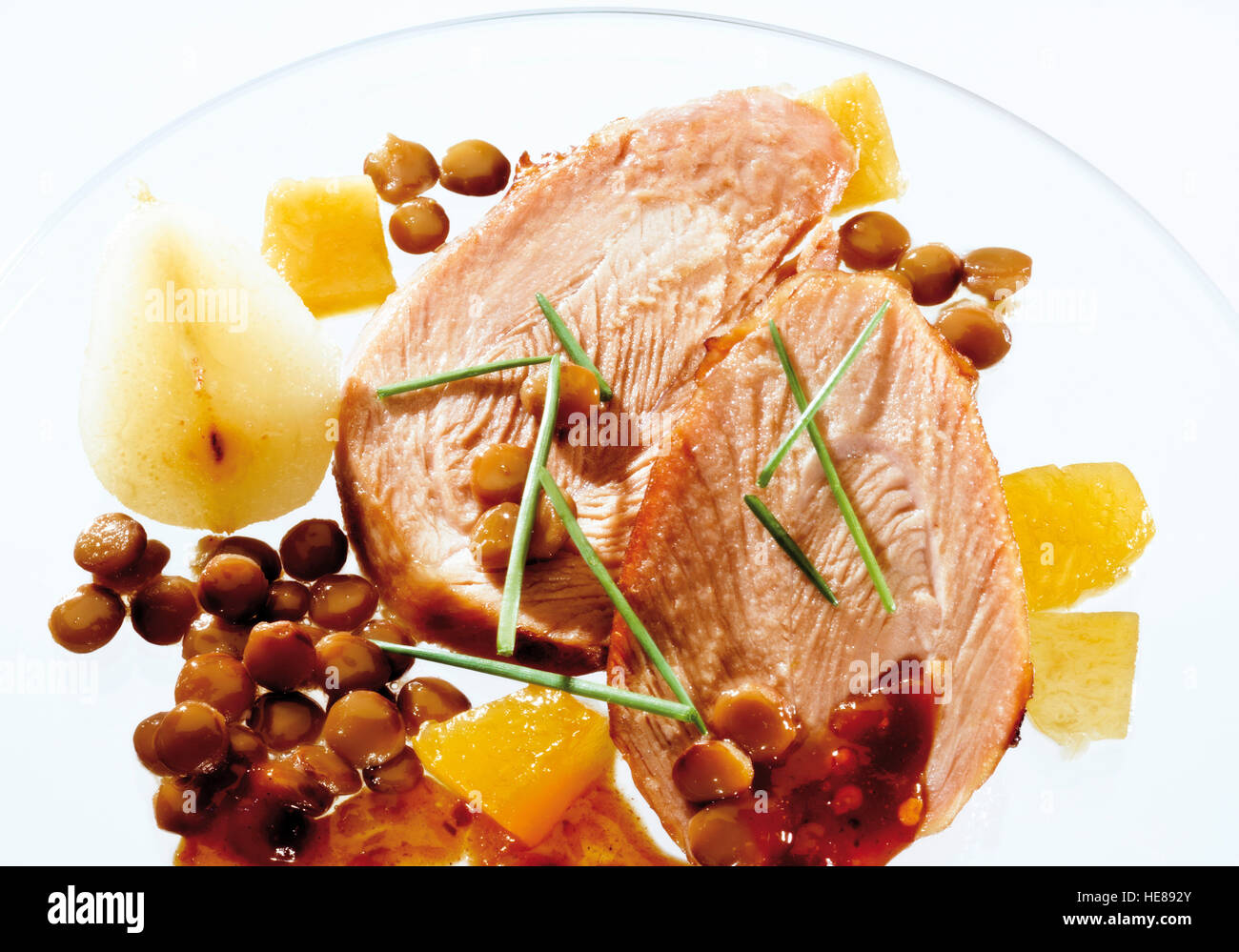 Two slices of roast pork with pears and lentils on a glass plate Stock Photo Alamy