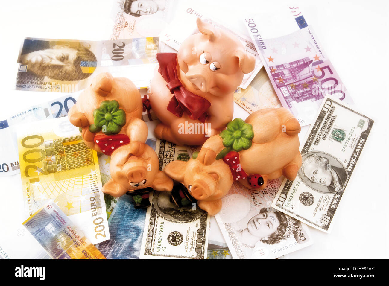 Pigs as a symbol of good luck with various currency banknotes Stock
