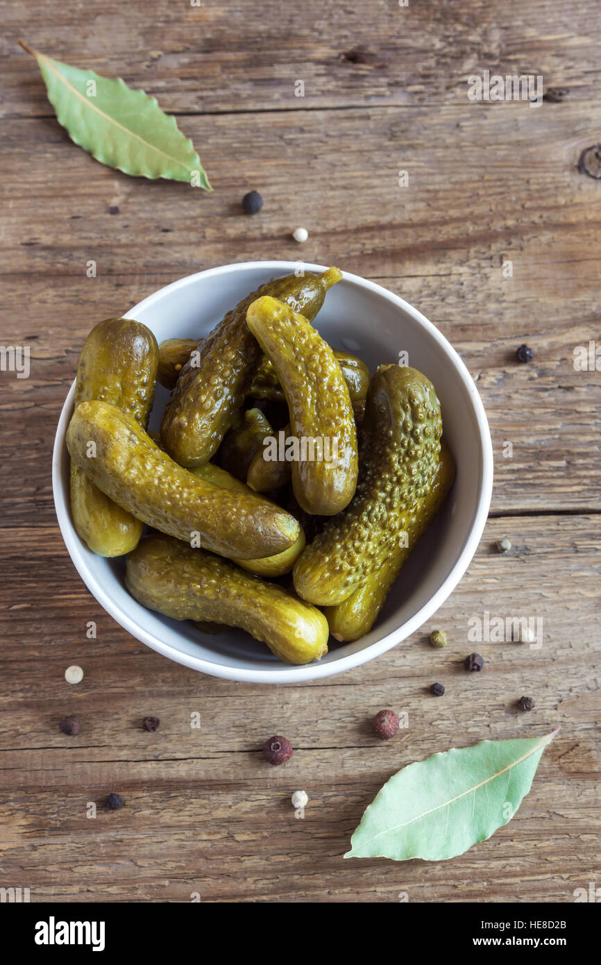 Pickles. Bowl of pickled gherkins (cucumbers) over rustic wooden background Stock Photo