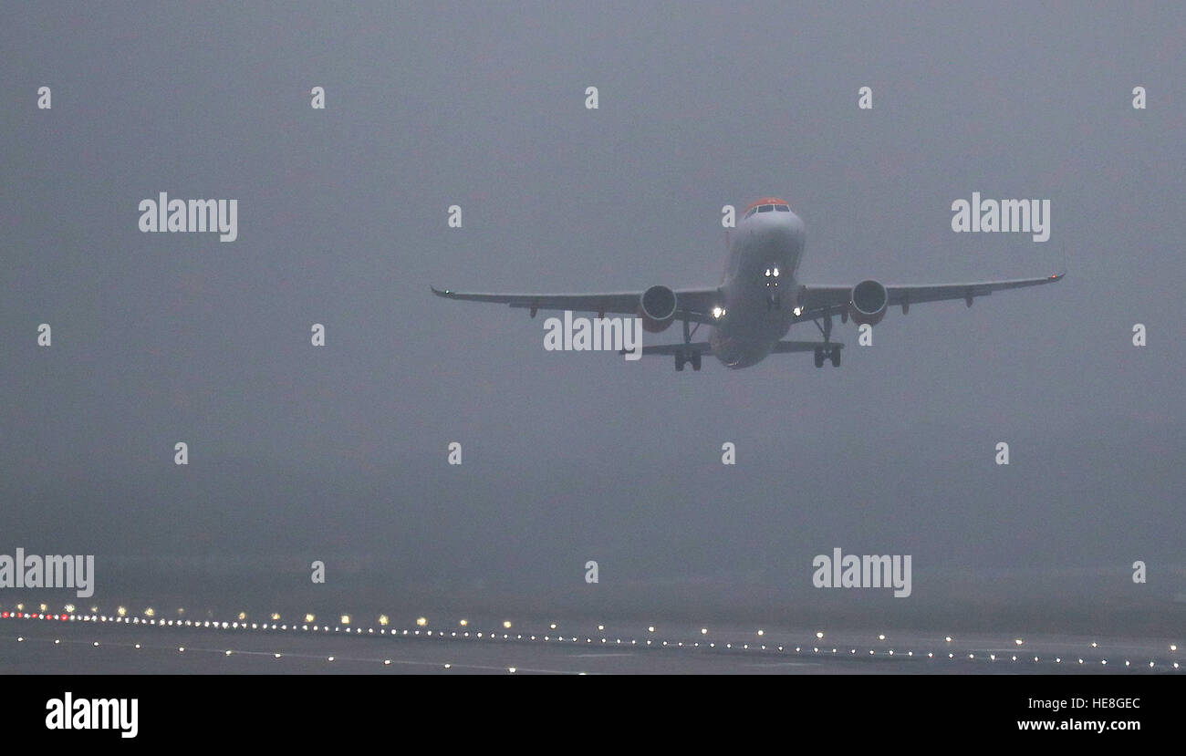 A plane takes off from Gatwick Airport in west Sussex, as thick fog ...