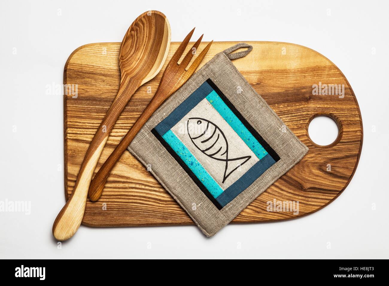 Kitchen equipment - wooden cutting board, tools and linen patchwork potholder Stock Photo