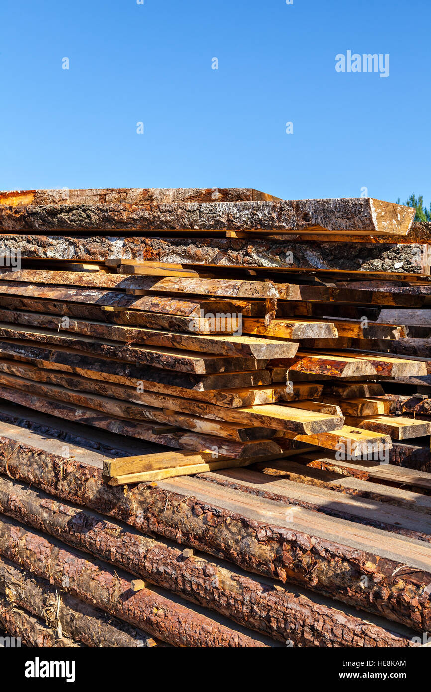 Image of stacked wooden balks and boards in a sawmill. Stock Photo