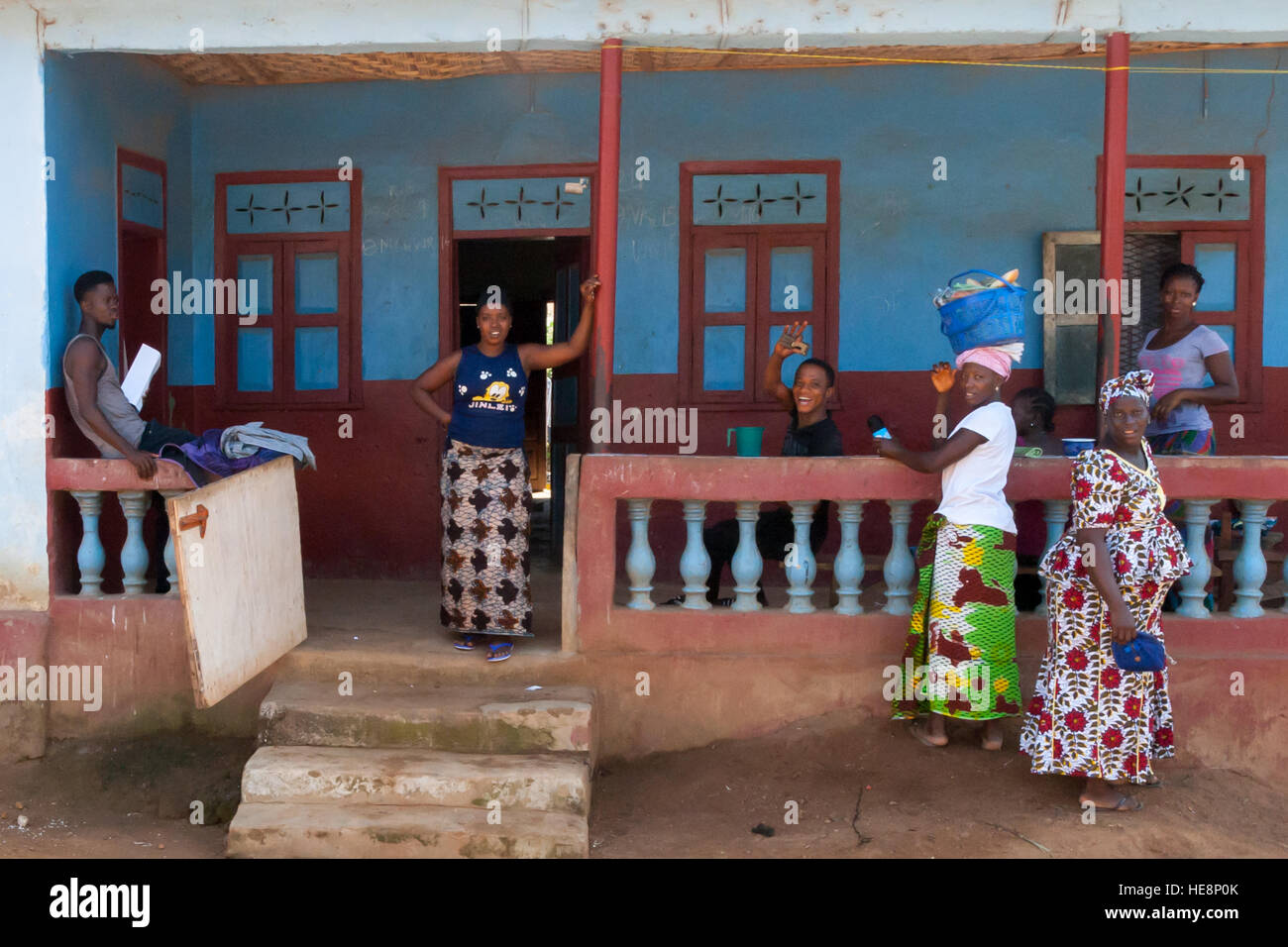 People in Sierra Leone on their veranda greeting and waving at camera Stock Photo