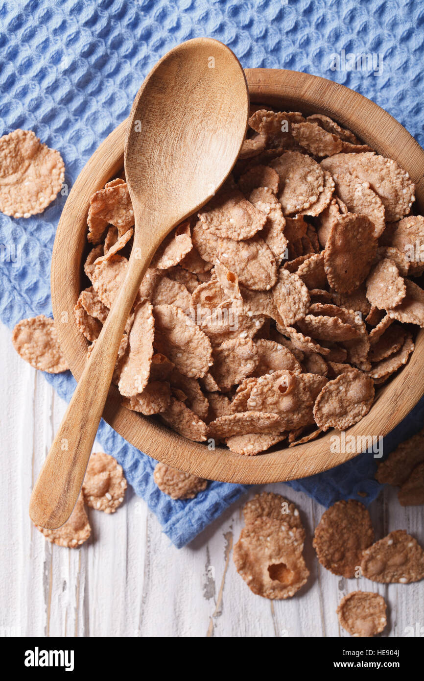 cereal flakes in a wooden bowl closeup. vertical top view, rustic style Stock Photo