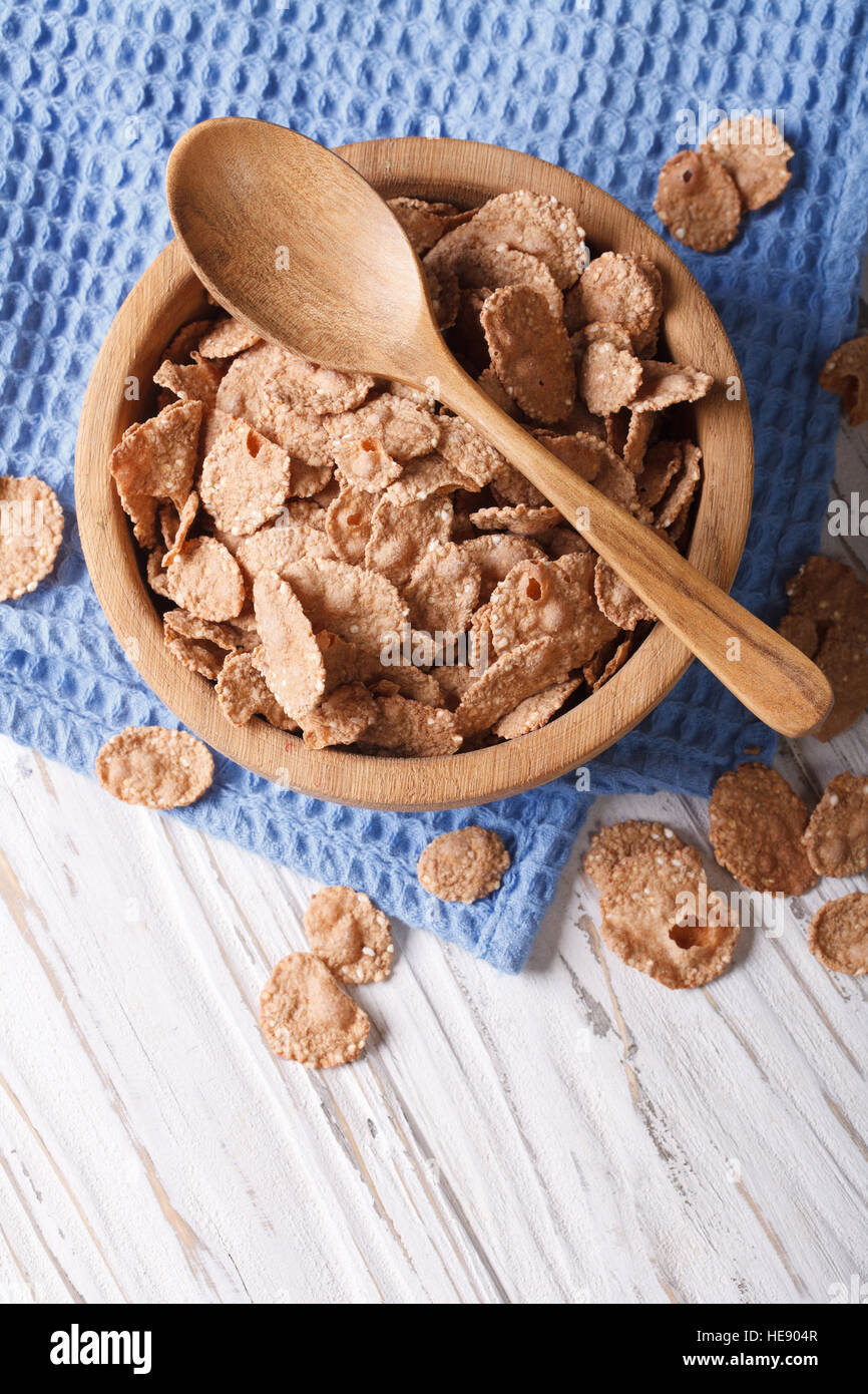 Healthy breakfast: Bran flakes in a wooden bowl closeup. vertical top view Stock Photo