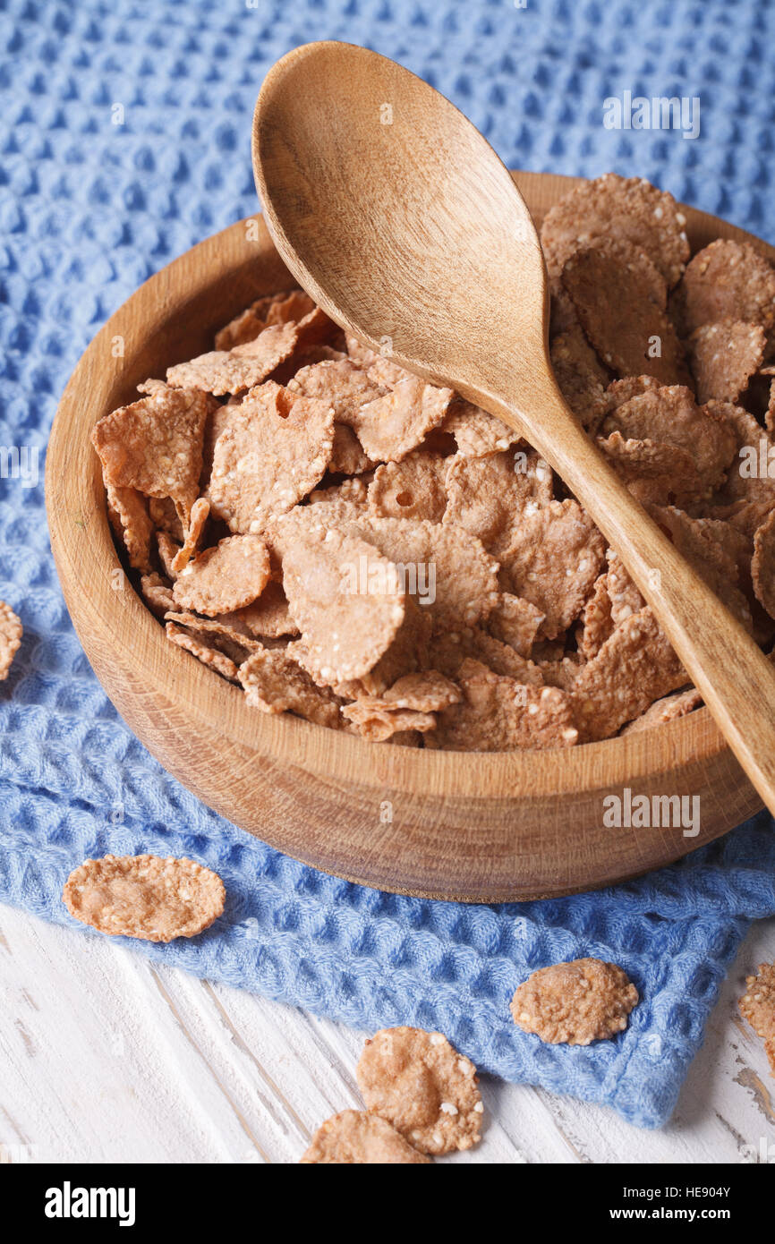 Healthy breakfast: Bran flakes in a wooden bowl closeup. Vertical Stock Photo