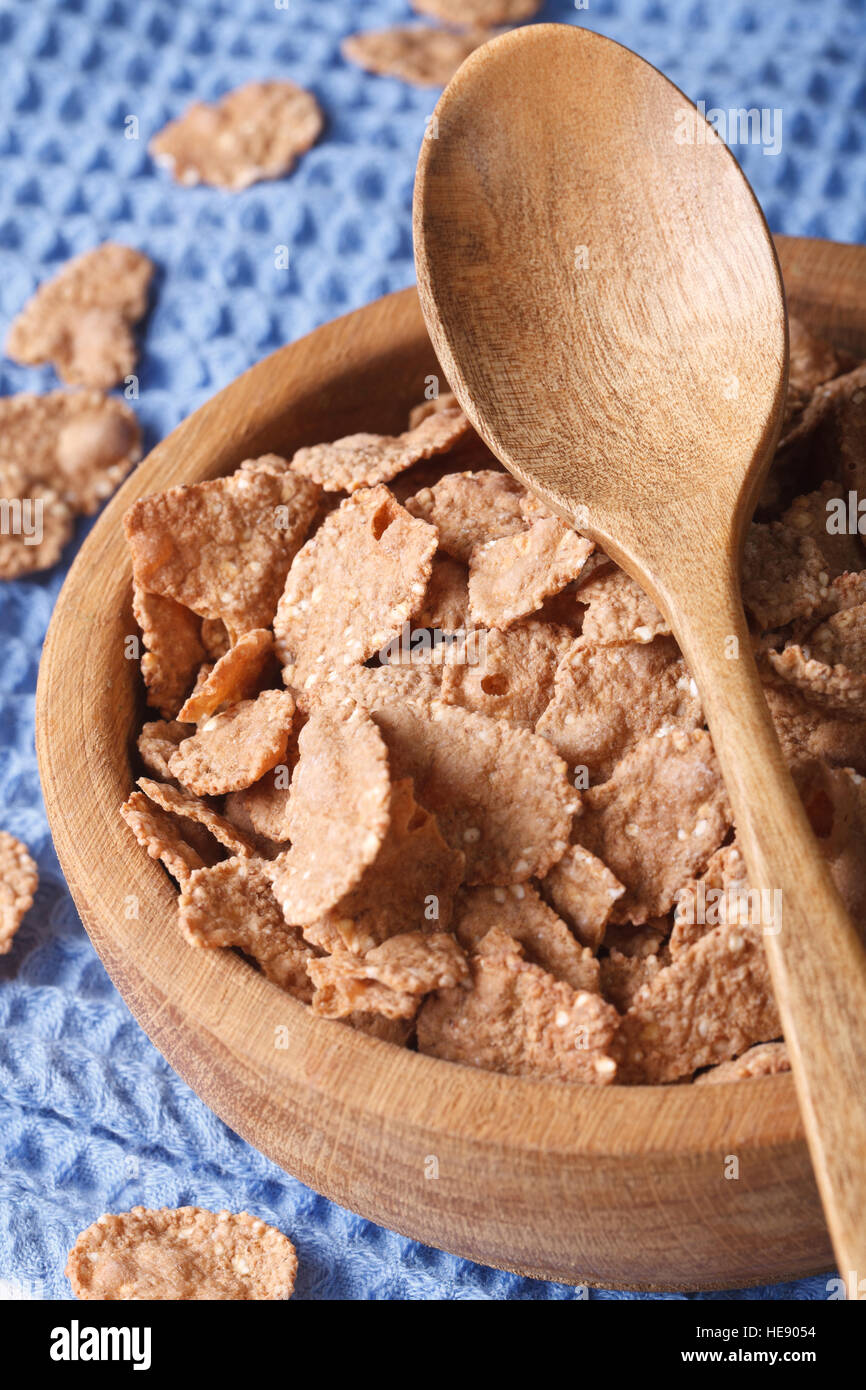 Dietary breakfast: bran flakes in a wooden bowl closeup. Vertical, rustic style Stock Photo
