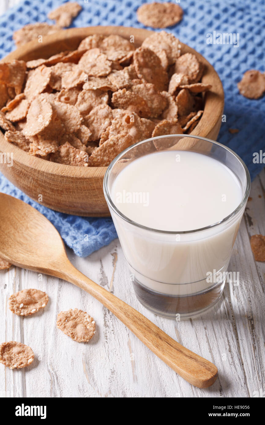 Fitness Breakfast: bran flakes in a wooden bowl and milk close-up. vertical, rustic style Stock Photo