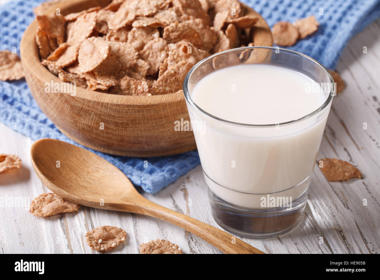 Fitness Breakfast: bran flakes in a wooden bowl and milk close-up. horizontal, rustic style Stock Photo
