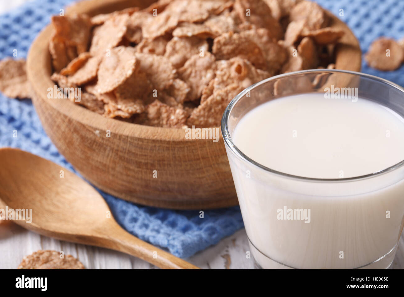 Healthy bran flakes in a wooden bowl and milk close-up. horizontal, rustic style Stock Photo