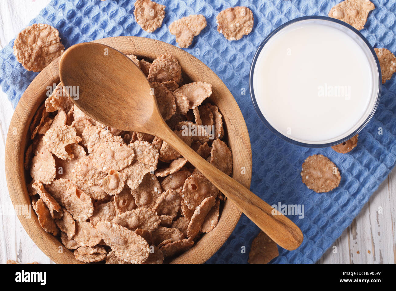 Cereal flakes in a wooden bowl and milk close-up. horizontal view from above Stock Photo