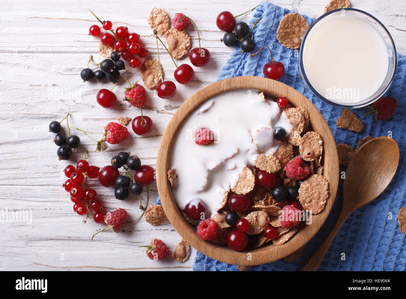 cereal with milk and fresh berries in a wooden bowl. horizontal view from above Stock Photo