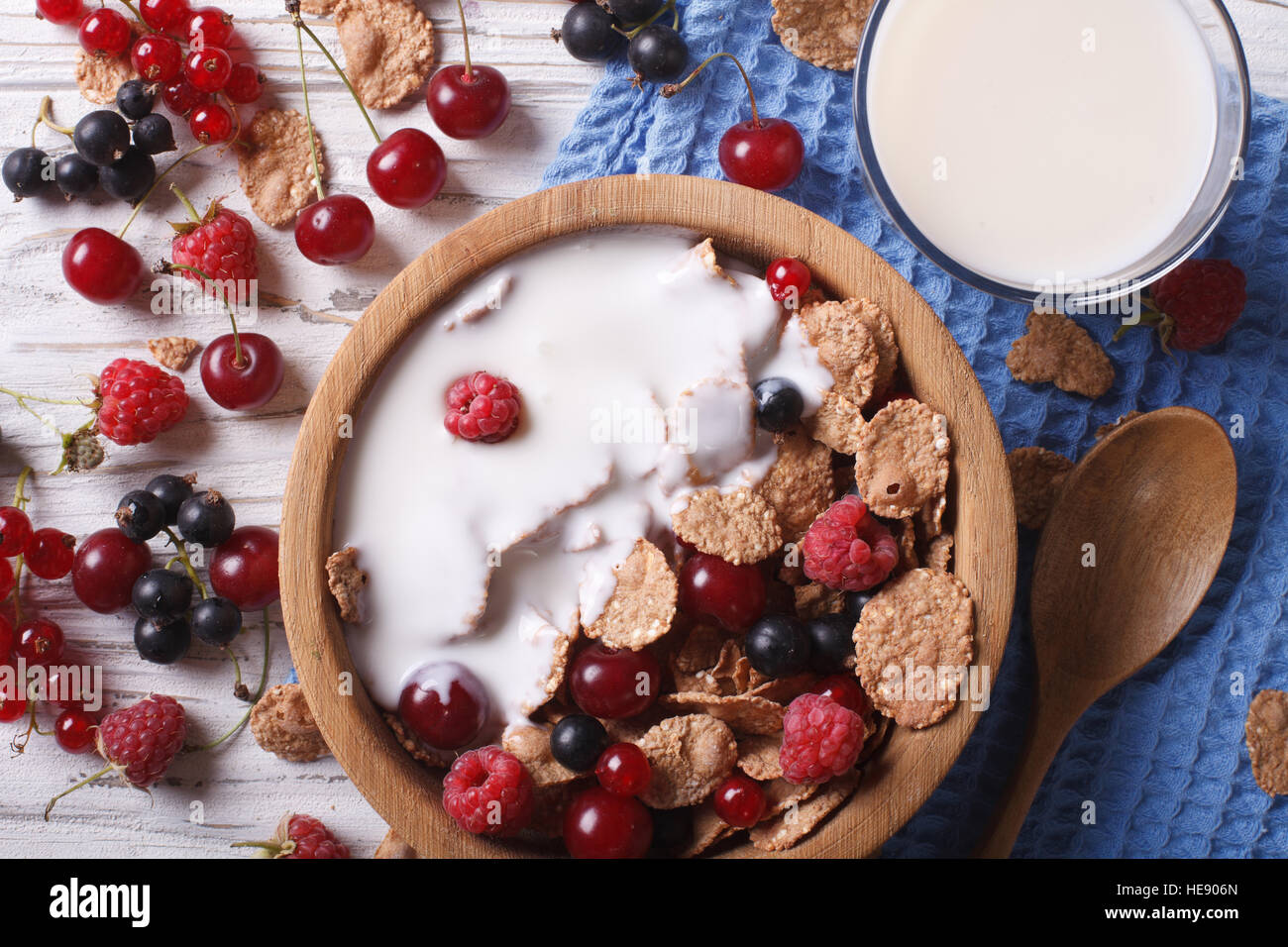 Muesli with milk and fresh berries close up in a wooden bowl. horizontal top view Stock Photo