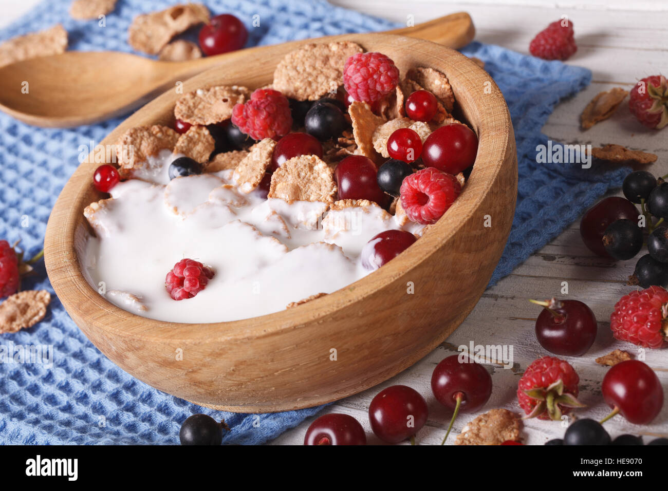Healthy breakfast: flakes with milk and berries close up in a wooden bowl. horizontal Stock Photo