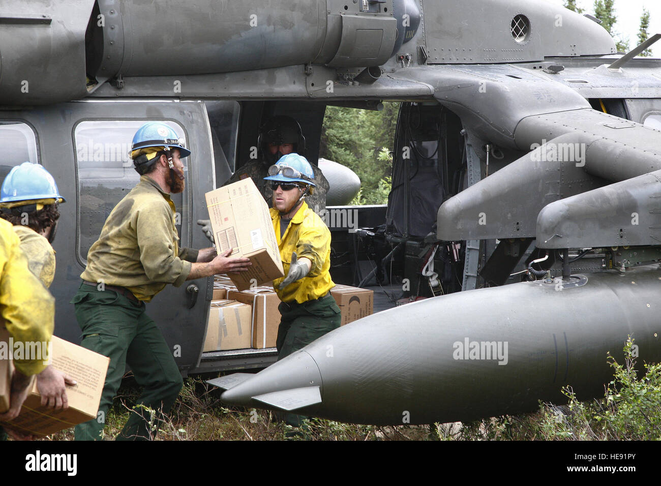 Wantana, ALASKA – Members of the U.S. Forest Service’s Lassen Interagency Hotshot Crew (IHC) of Susanville, Calif., load supplies onto an Alaska Army National Guard UH-60L Blackhawk helicopter during extraction operations, June 30, 2013.  The 21-member IHC was transported back to Palmer after completing containment and mop-up operations of the 40-acre wildfire.  Percy G. Jones) Stock Photo