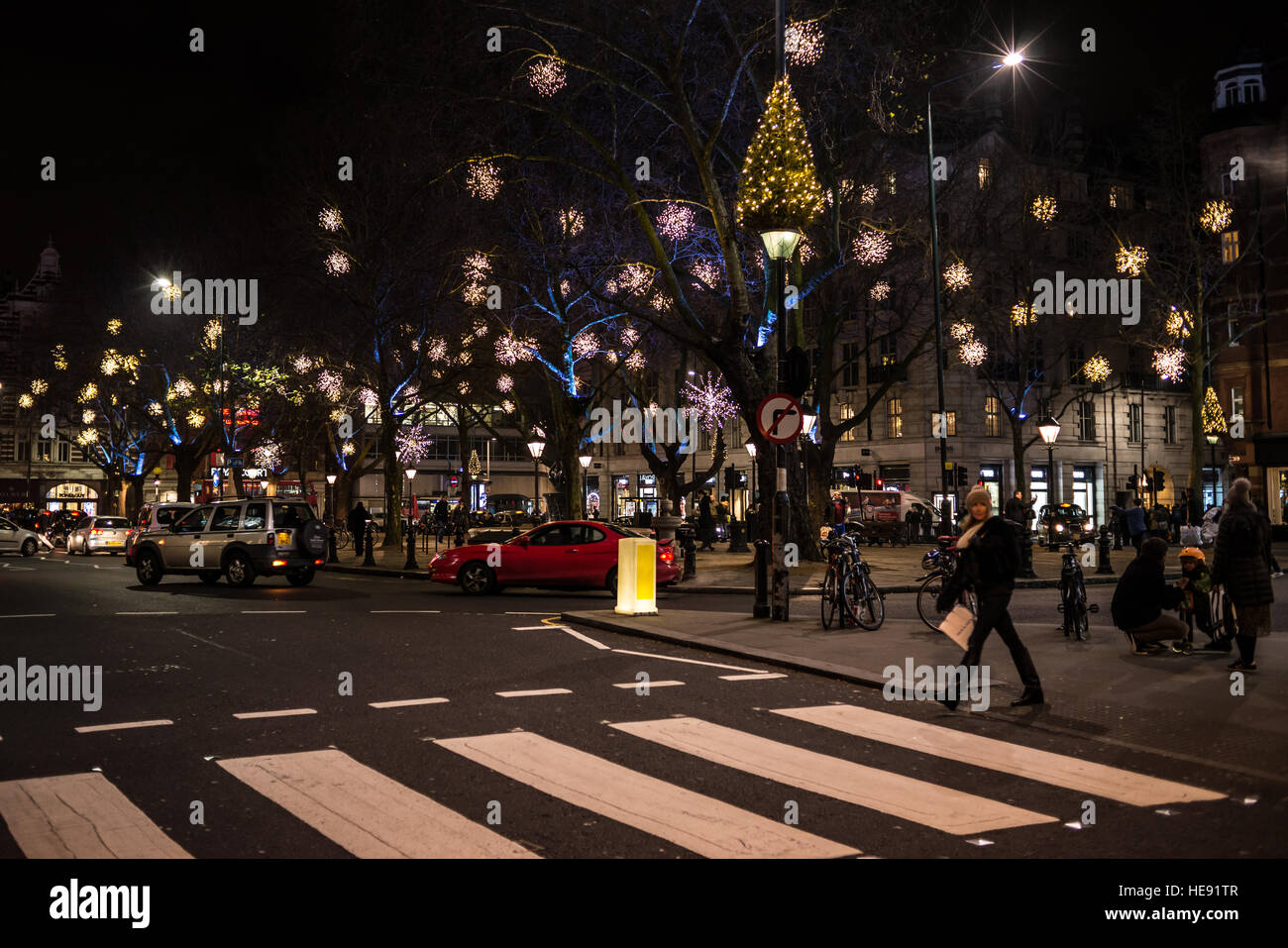 London, England - 17 December 2016: Night view of Sloane Square with Christmas light decorations and people crossing the road in Chelsea, London, UK. Stock Photo