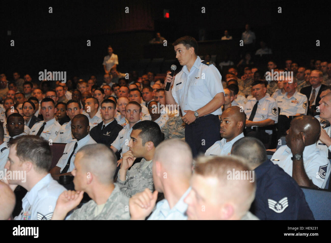 U.S. Air Force Maj. George Kotti, standing, with the 81st Medical Operations Squadron, poses a question to Gen. Edward Rice, not pictured, the commander of Air Education and Training Command (AETC), and Chief Master Sgt. Gerardo Tapia, not pictured, the command chief of AETC, during an all call in Welch Theater at Keesler Air Force Base, Miss., June 10, 2013.  Kemberly Groue Stock Photo