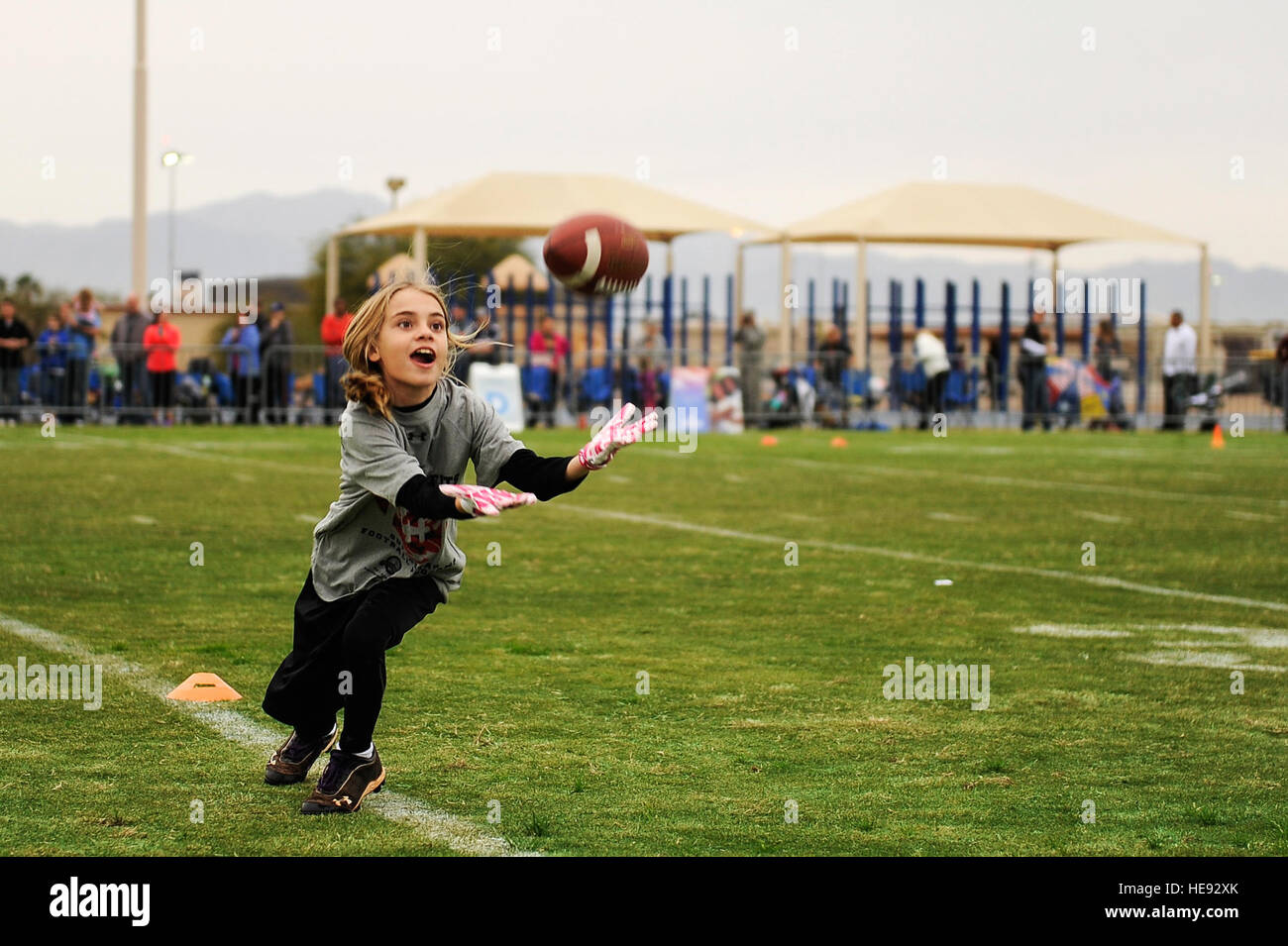 Jillian Artiges, daughter of Maj. Michael Artiges, 308th Fighter Squadron assistant director of operations, catches a pass during a youth football camp at Luke Air Force Base, Ariz., Jan. 29, 2015. The camp ran by ProCamps Worldwide, specialized in football fundamentals, with campers receiving instruction from NFL players and football coaches from the local area.  Staff Sgt. Staci Miller Stock Photo
