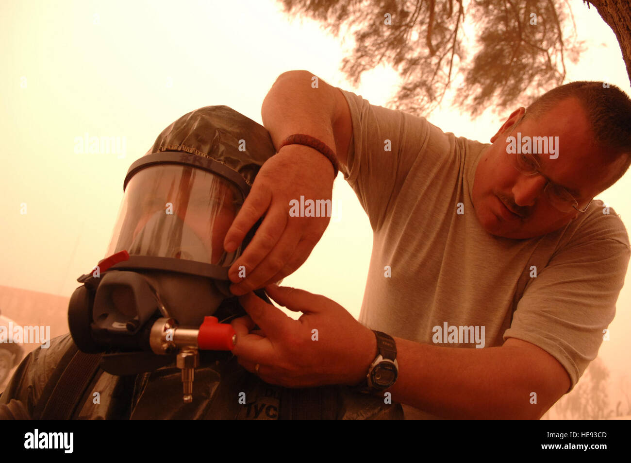 Master Sgt. Stephen Jakle (right), 407th Expeditionary Civil Engineer Squadron emergency manager from Ali Base, helps Staff Sgt. Amber Albano, 506th Expeditionary Civil Engineer Squadron emergency manager from Kirkuk Regional Air Base, put on her oxygen mask before she investigated an unknown powder substance during a training scenario, April 17. The suits worn by the team members allow them to respond to real world situations and can protect against chemical, biological, radiological and nuclear materials. Being confident and comfortable with their equipment allows emergency managers to focus Stock Photo