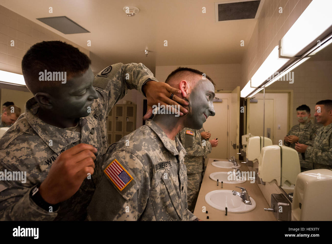 Army Staff Sgt. Jerome Willis and Spc. Trevor Holzmeister, paratroopers assigned to B Company, 3rd Battalion (Airborne), 509th Infantry Regiment, 4th Brigade Combat Team (Airborne), 25th Infantry Division, U.S. Army Alaska, don camouflage face paint in preparation for a show of force demonstration at Arctic Thunder Open House 2014, July 26, 2014. Arctic Thunder is a biennial event hosted by Joint Base Elmendorf-Richardson, Alaska. Featuring more than 40 Air Force, Army and civilian aerial acts and an expected crowd of more than 200,000 people, it is the largest two-day event in the state and o Stock Photo