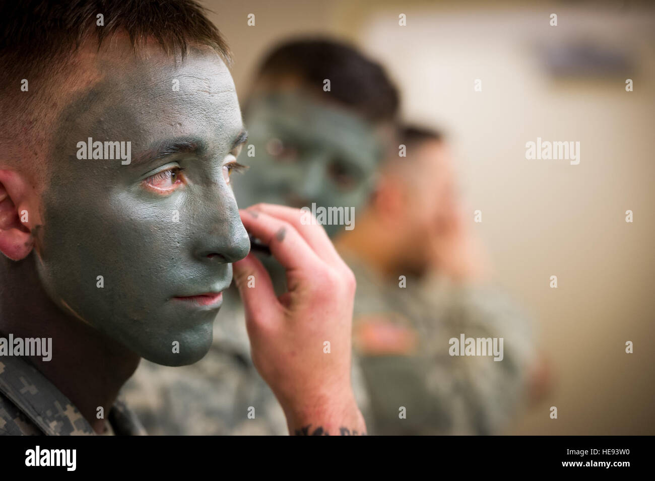 Army Spc. Trevor Holzmeister, a paratrooper assigned to B Company, 3rd Battalion (Airborne), 509th Infantry Regiment, 4th Brigade Combat Team (Airborne), 25th Infantry Division, U.S. Army Alaska, dons camouflage face paint in preparation for a show of force demonstration at Arctic Thunder Open House 2014, July 26, 2014. Arctic Thunder is a biennial event hosted by Joint Base Elmendorf-Richardson, Alaska. Featuring more than 40 Air Force, Army and civilian aerial acts and an expected crowd of more than 200,000 people, it is the largest two-day event in the state and one of the premier aerial de Stock Photo