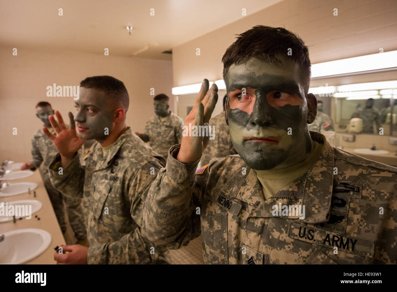 Army Staff Sgts. Benjamin Nenno and Jerome Willis, paratroopers assigned to B Company, 3rd Battalion (Airborne), 509th Infantry Regiment, 4th Brigade Combat Team (Airborne), 25th Infantry Division, U.S. Army Alaska, don camouflage face paint in preparation for a show of force demonstration at Arctic Thunder Open House 2014, July 26, 2014. Arctic Thunder is a biennial event hosted by Joint Base Elmendorf-Richardson, Alaska. Featuring more than 40 Air Force, Army and civilian aerial acts and an expected crowd of more than 200,000 people, it is the largest two-day event in the state and one of th Stock Photo