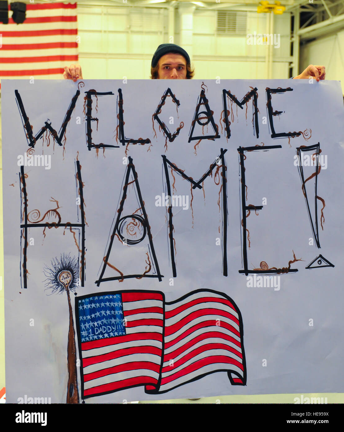 A man holds a welcome home sign in the Freedom Hangar at Hurlburt Field, Fla., Jan. 12, 2014. Nearly 50 U.S. Airmen returned home from various deployed locations.  Staff Sgt. John Bainter Stock Photo