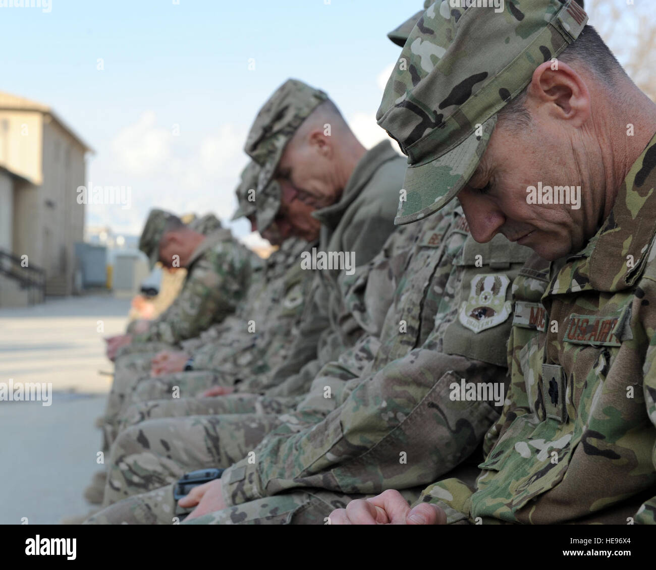 U.S. service members bow their heads during a remembrance ceremony honoring special operators who were killed March 4, 2002, during Operation Anaconda: U.S. Air Force Senior Airman Jason Cunningham, U.S. Army Cpl. Matthew Commons, U.S. Army Spc. Marc Anderson, U.S. Army Sgt. Phillip Svitak, U.S. Army Sgt. Bradley Crose, U.S. Navy Petty Officer 1st Class Neil Roberts and U.S. Air Force Tech. Sgt. John Chapman, March 3, 2015 at Bagram Air Field, Afghanistan. Service members from all branches conducted a 24-hour vigil run and a retreat ceremony to honor the 13th anniversary of their deaths and pa Stock Photo