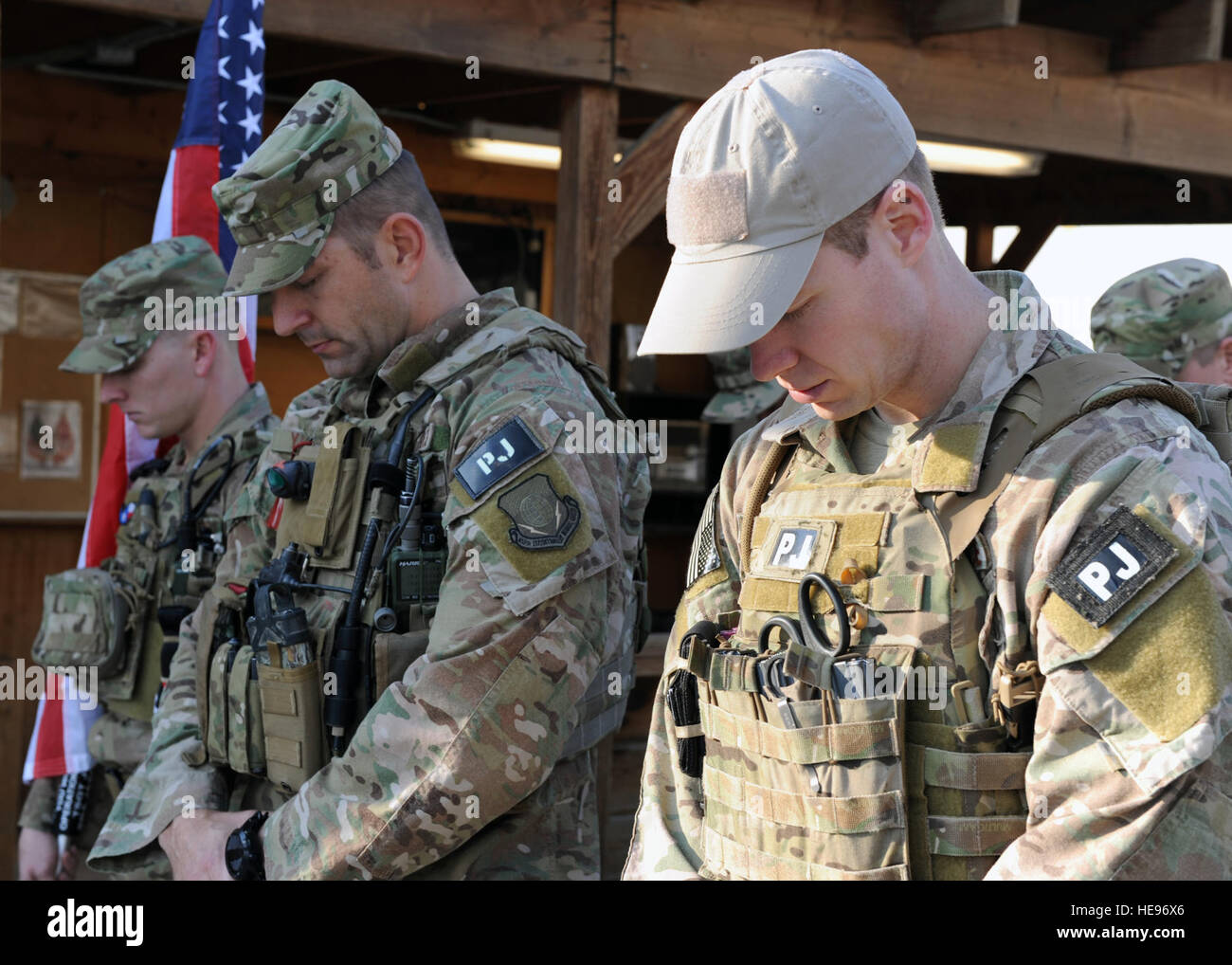 Pararescumen assigned to the 83rd Expeditionary Rescue Squadron bow their heads during a remembrance ceremony honoring special operators who were killed March 4, 2002, during Operation Anaconda: U.S. Air Force Senior Airman Jason Cunningham, U.S. Army Cpl. Matthew Commons, U.S. Army Spc. Marc Anderson, U.S. Army Sgt. Phillip Svitak, U.S. Army Sgt. Bradley Crose, U.S. Navy Petty Officer 1st Class Neil Roberts and U.S. Air Force Tech. Sgt. John Chapman, March 3, 2015 at Bagram Air Field, Afghanistan. Service members from all branches conducted a 24-hour vigil run and a retreat ceremony to honor  Stock Photo