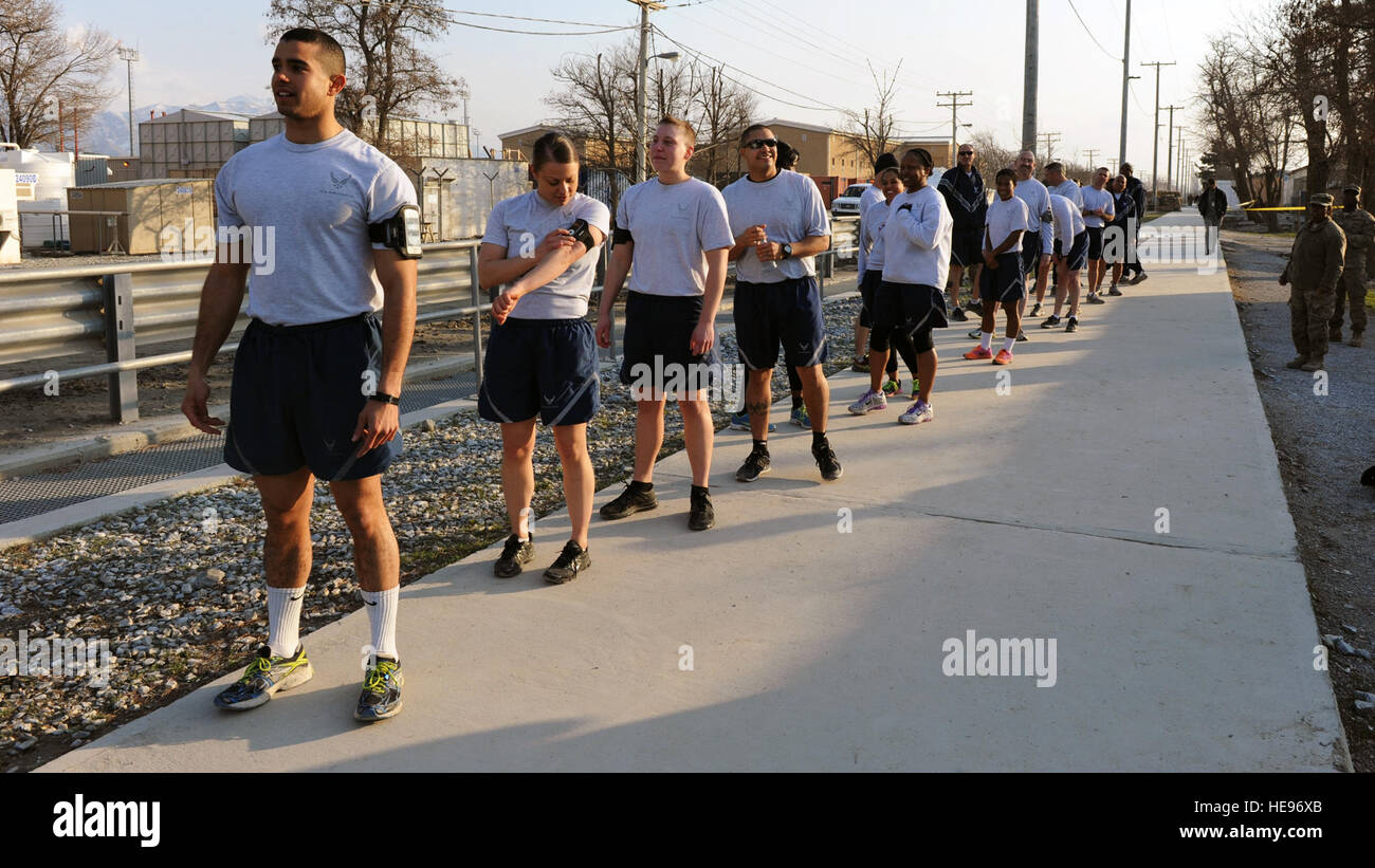 U.S. Air Force Airmen prepare to run with a U.S. flag bearing the names of seven special operators who were killed March 4, 2002 during Operation Anaconda: U.S. Air Force Senior Airman Jason Cunningham, U.S. Army Cpl. Matthew Commons, U.S. Army Spc. Marc Anderson, U.S. Army Sgt. Phillip Svitak, U.S. Army Sgt. Bradley Crose, U.S. Navy Petty Officer 1st Class Neil Roberts and U.S. Air Force Tech. Sgt. John Chapman, March 3, 2015 at Bagram Air Field, Afghanistan. Service members from all branches conducted a 24-hour vigil run and a retreat ceremony to honor the 13th anniversary of their deaths an Stock Photo