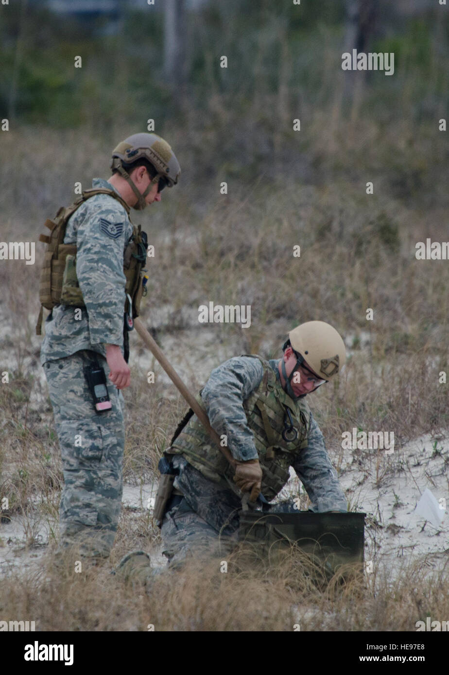 Tech. Sgt. Brian Dunnagan, 1st Special Operations Civil Engineer Squadron explosive ordnance disposal craftsman, and Senior Airman Christopher Dolan, 919th Special Operations Squadron explosive ordnance journeyman place an unexploded ordnance into an ammo can at Perdido Key, Fla., March 12, 2014. Dunnagan and Dolan exploded the device with C4, a safe distance from the roadway. Staff Sgt. John Bainter) Stock Photo