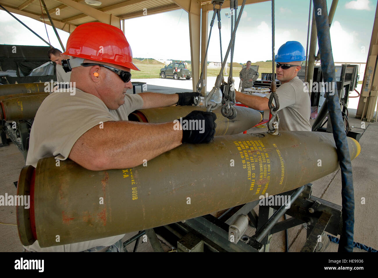 Master  Sergeant Tommy Nash (left) and Staff Sergeant Adam Gilbert of the Ammo Build Crew from the 169th Fighter Wing, McEntire Joint National Guard Base, South Carolina, lift unassembled Mark 82 (Mk-82) bomb components from a Munitions Assembly Conveyor (MAC) at Shaw AFB.  The Mark 82's were built to use in future live fire exercises. The McEntire crew, comprised of Guardsmen and Active-Associate Airmen, spent 3-days at Shaw building the bombs. (USAF  MSgt. Marvin R. Preston, 169th FW/PA) Stock Photo
