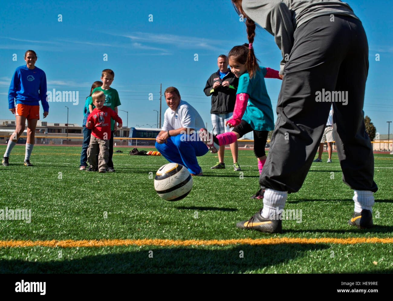 131005-F-WU507-052:  Sporting a ‘Kiss my cleats’ shirt, six-year-old Iris Hartzell, daughter of Maggie and Air Force Staff Sgt. Brendan Hartzell, 366th Communications Squadron, takes a shot at goal at Mountain Home Air Force Base, Idaho, Oct. 5, 2013. The keeper was one of fourteen Boise State University ladies soccer players who visited base as part of their Military Appreciation Day.  Master Sgt. Kevin Wallace/) Stock Photo