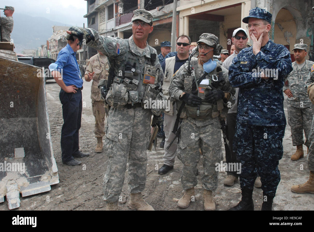 Lt. Col. Keith Pellegrini, commander of 2nd Brigade Special Troops Battalion, 2nd Brigade Combat Team, left, shows Navy Adm. Mike Mullen, chairman of the Joint Chiefs of Staff, around a rubble removal site in Port-au-Prince on Feb. 26. Mullen visited the area to see the progress of the rubble removal mission, a joint effort between Italian Interagency Task Force soldiers, the Center of National Equipment, and 2BCT Paratroopers.  Pfc. Kissta M. Feldner, 2BCT PAO) Stock Photo