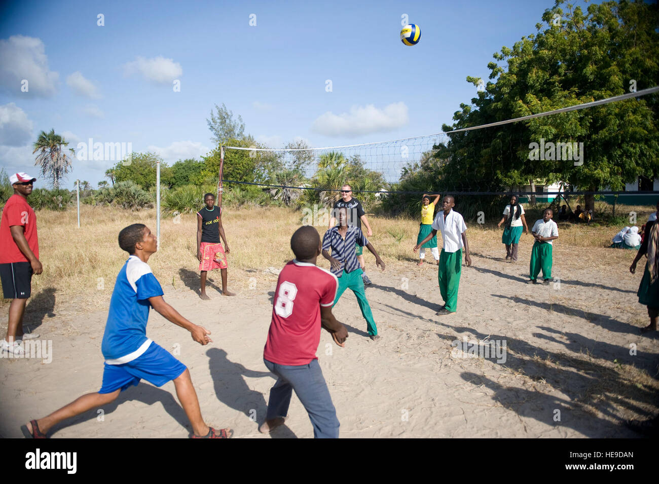 Students from the Mokowe Primary School play volleyball with members of
