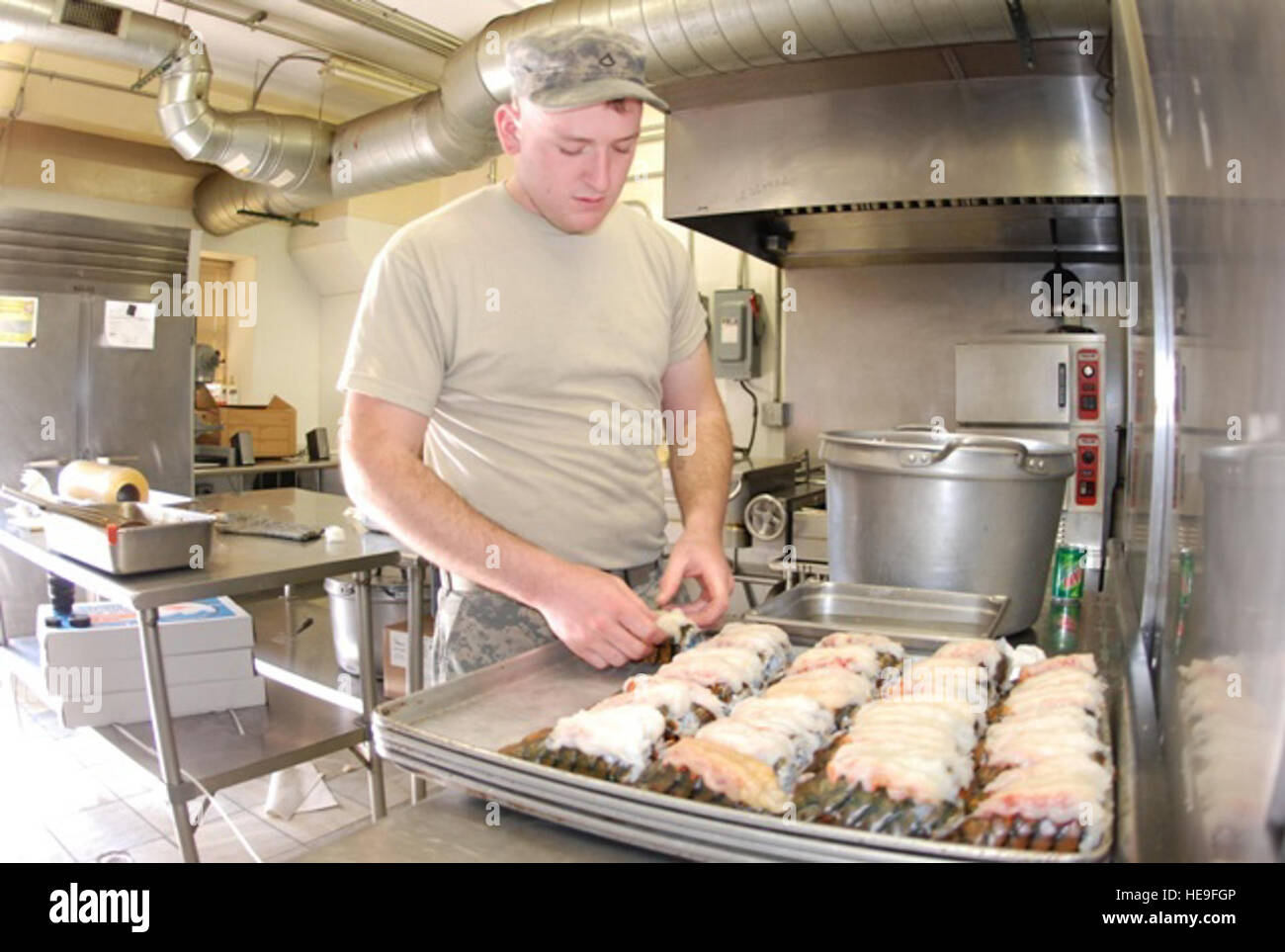 U.S. Army Pfc. Michael Gunther, a food services specialist with the 82nd Airborne, prepares lobsters for dinner at the dining facility inside the Combined Joint Task Force-82 Joint Operations Center, Feb. 12. A native of Fort Leonard Wood, Mo. Gunther and his team mates serve more than 900 meals per day at the dining facility inside of the Combined Joint Task Force-82 Joint Operations Center. During the holidays, the dining facility crew members plan for more elaborate festivities and spend extra hours to prepare those special meals. Stock Photo