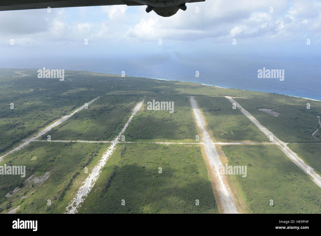 A U.S. Air Force C-130H Hercules flies over North Field, Tinian, Marianna Islands, during Cope North 15, Feb. 26, 2015. North Field served as the World War II headquarters for the 509th Composite Group that launched the atomic bomb attacks against Hiroshima and Nagasaki, Japan, in August of 1945. Through training exercises such as Exercise Cope North 15, the U.S., Japan and Australia air forces develop combat capabilities, enhancing air superiority, electronic warfare, air interdiction, tactical airlift and aerial refueling.  Tech. Sgt. Jason Robertson Stock Photo