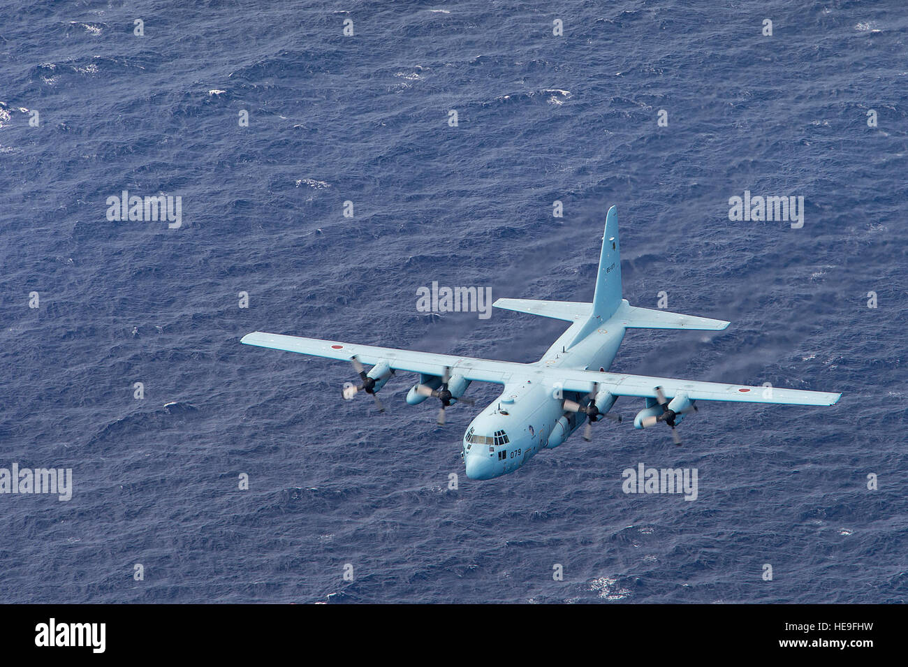 A Japan Self-Defense Force C-130 Hercules flies off the coast of North Field, Tinian, Marianna Islands, during Cope North 15, Feb. 26, 2015. North Field served as the World War II headquarters for the 509th Composite Group that launched the atomic bomb attacks against Hiroshima and Nagasaki, Japan, in August of 1945. Through training exercises such as Exercise Cope North 15, the U.S., Japan and Australia air forces develop combat capabilities, enhancing air superiority, electronic warfare, air interdiction, tactical airlift and aerial refueling.  Tech. Sgt. Jason Robertson Stock Photo