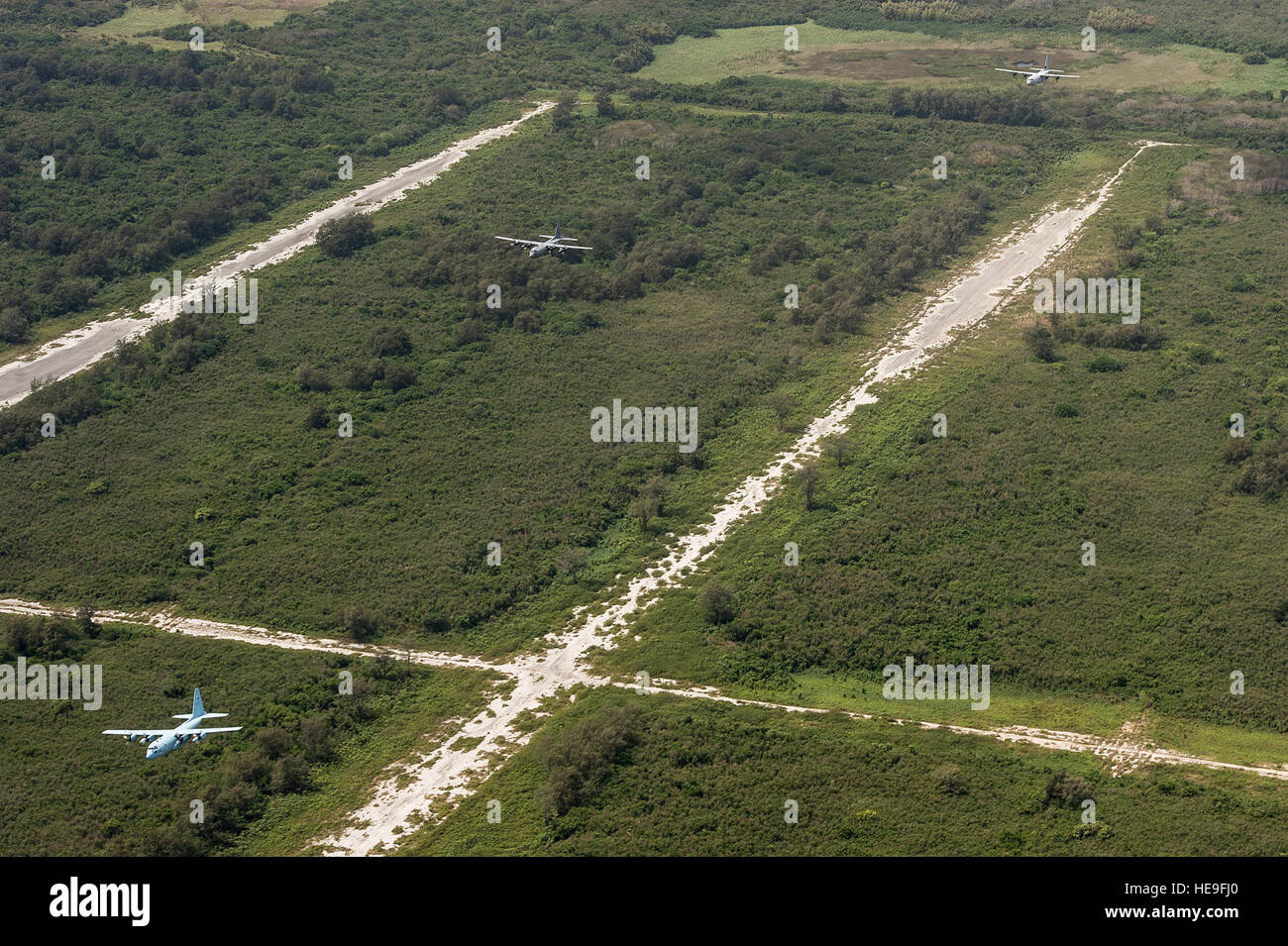 A formation of Japan Self-Defense Force, U.S. Air Force and Royal Australian Air Force C-130 Hercules aircraft fly over North Field, Tinian, Marianna Islands, during Cope North 15, Feb. 26, 2015. North Field served as the World War II headquarters for the 509th Composite Group that launched the atomic bomb attacks against Hiroshima and Nagasaki, Japan, in August of 1945. Through training exercises such as Exercise Cope North 15, the U.S., Japan and Australia air forces develop combat capabilities, enhancing air superiority, electronic warfare, air interdiction, tactical airlift and aerial refu Stock Photo