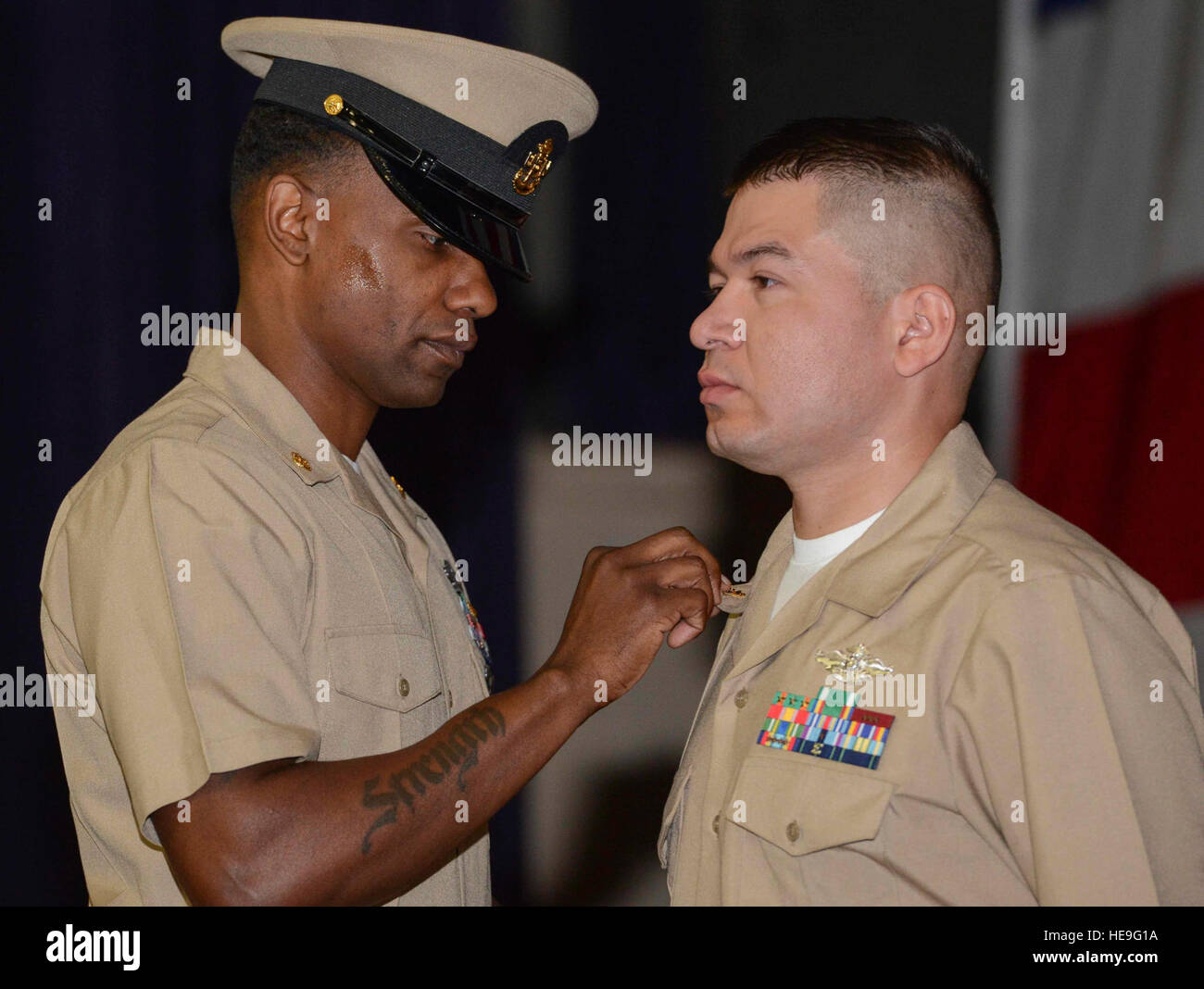 150916-N-QY316-093    NAVAL BASE KITSAP – BREMERTON, Wash. (Sep. 16, 2015) Chief Religious Program Specialist Juan Bejarano, assigned to the aircraft carrier USS Nimitz (CVN 68), receives his anchors from Chief Religious Programs Specialist Stanley Ponder, during Nimitz’ chief pinning ceremony held at Naval Base Kitsap-Bremerton.  Twenty-one Sailors on board Nimitz were selected and pinned to the rank of chief petty officer, after having participated in an intense, six-week program intended to train first class petty officers on the roles and responsibilities of becoming a chief. Mass Communic Stock Photo