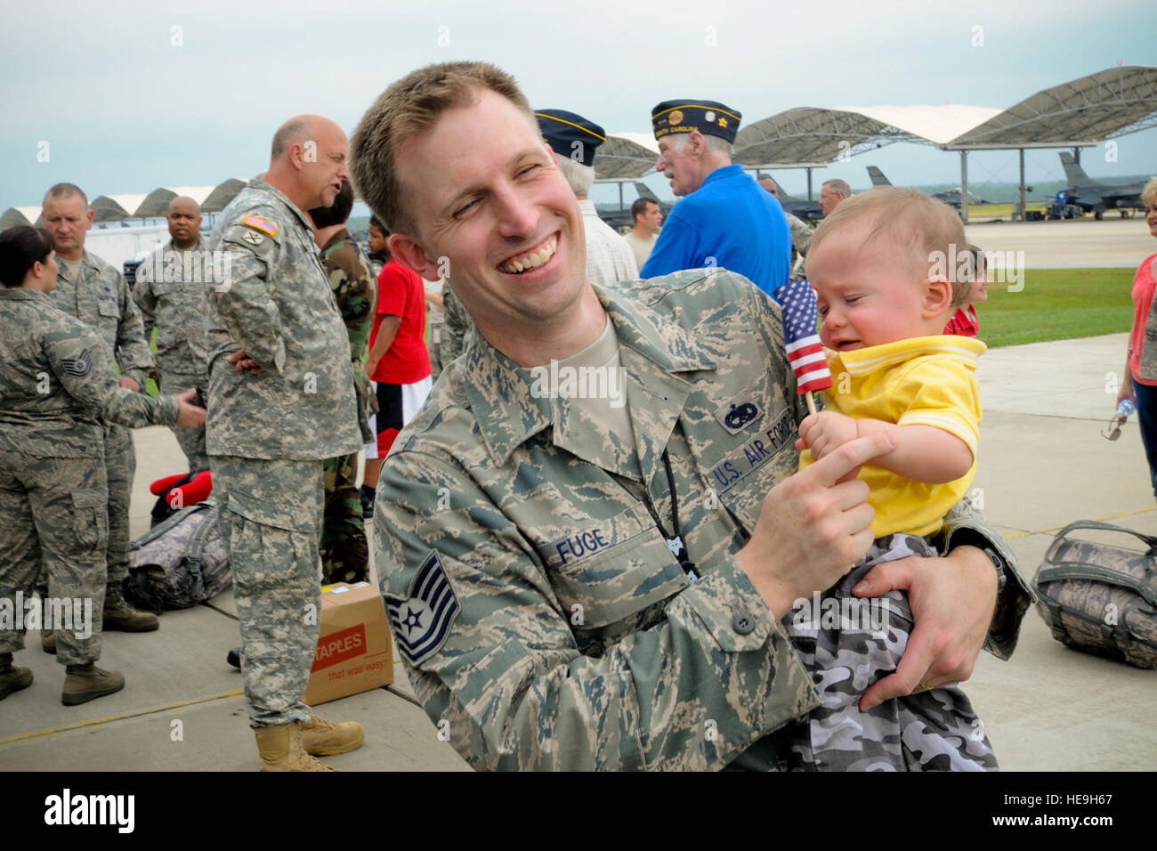 Technical Sgt. Mark Fuge assigned to the 169th Maintenance Operation Flight shares a laugh with his son just before boarding a bus to his plane. Airmen from the 169th Fighter Wing are deploying to Southwest Asia in support of Operation Iraqi Freedom. The deployment includes F-16 fighter jets, pilots, maintenance specialists and other support personnel, commonly referred to as an aviation package.  Master Sgt. Marvin Preston, 169th FW Stock Photo