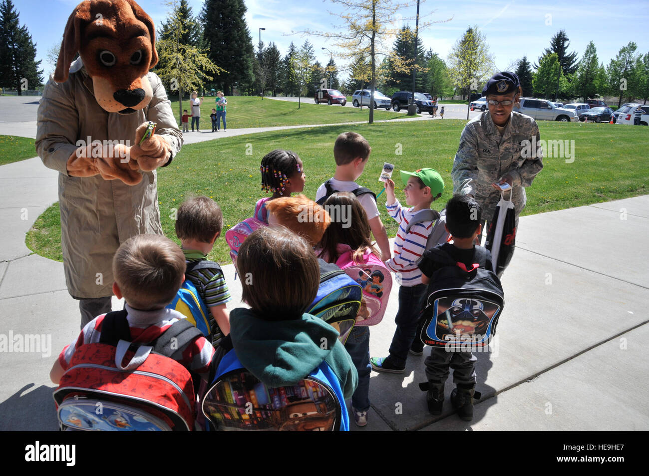 Scruff McGruff, the Crime Dog, and Staff Sgt. Denine Deal pass out pencils and stickers to a group of children from Michael Anderson Elementary School at Fairchild Air Force Base, Wash., May 14, 2014. McGruff and Deal spoke with children about staying safe and being aware of their surroundings.  Senior Airman Mary O'Dell Stock Photo