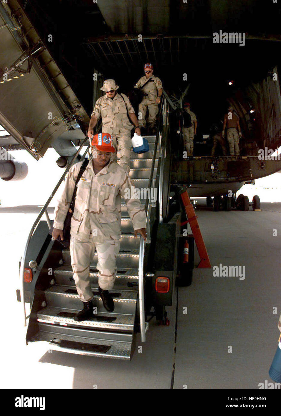 960807-F-2829R-005  U.S. Air Force engineers from the 823rd Red Horse Squadron step off of a C-5B Galaxy at Prince Sultan Air Base at Al Kharj, Saudi Arabia, on August 7, 1996.  The Galaxy is bringing in engineers, equipment and supplies to construct a tent city to house U.S. personnel conducting Operation Southern Watch.  Nearly 4,000 personnel, aircraft, and equipment are being moved from bases in Dhahran and Riyadh to the remote desert air base to reduce their vulnerability to terrorist attack.  Southern Watch is the U.S. and coalition enforcement of the no-fly-zone over Southern Iraq.  The Stock Photo