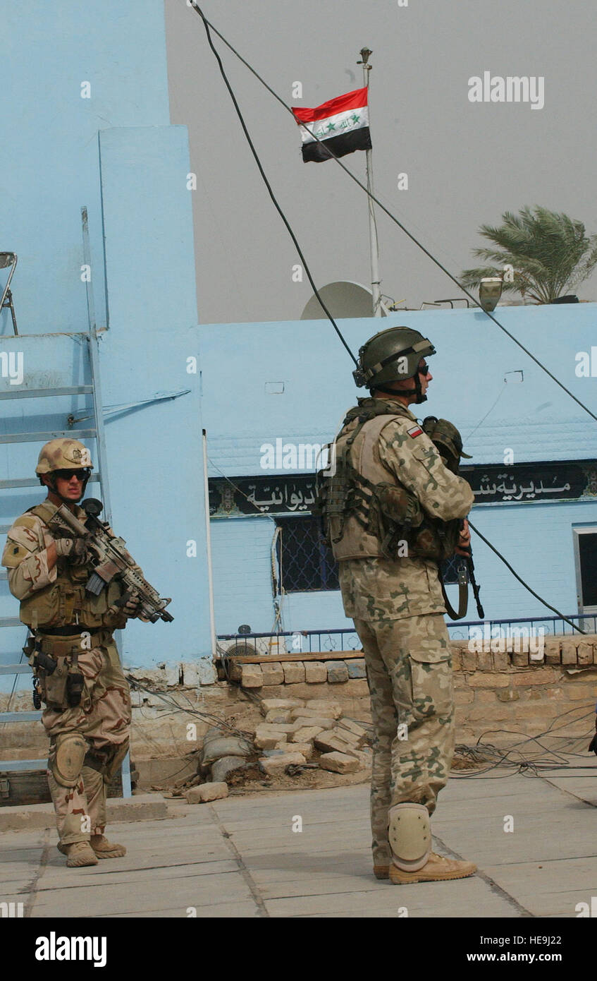 A Polish army soldier, right, and a U.S. Navy Explosive Ordnance Disposal team member from Camp Echo, Iraq, provide security for other team members as they conduct official business at the Iraqi police headquarters in Ad Diwaniyah, Iraq.  Tech. Sgt. Dawn M. Price) (Released) Stock Photo
