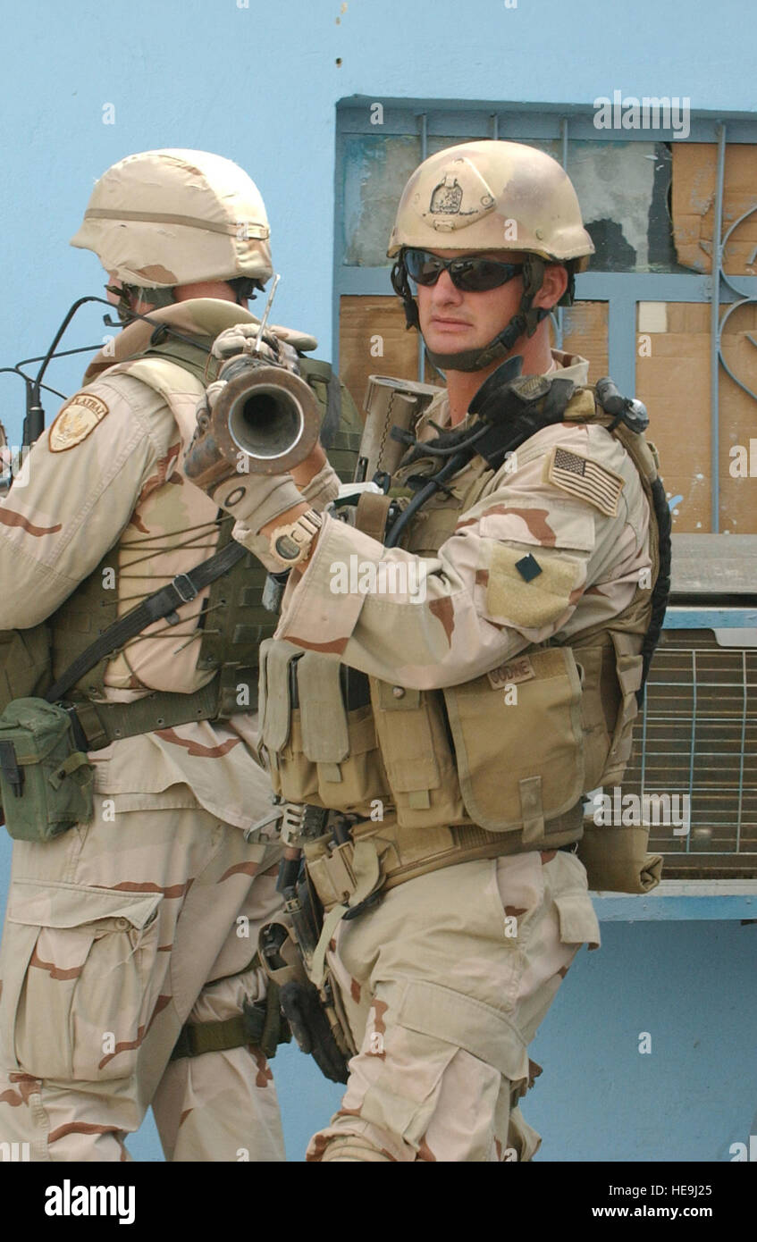 U.S. Navy Explosive Ordnance Technician 1st Class Travis J. Schellpeper carries an RPG tube out of the Iraqi police headquarters in Ad Diwaniyah, Iraq, Oct. 30, 2006, for transport to Camp Echo, Iraq.  The U.S. Navy EOD Mobile Unit 3 responded to the Iraqi police headquarters to recover a cache of explosives found by policemen during a checkpoint vehicle search.  Schellpeper is the team leader of the U.S. Navy Explosive Ordnance Disposal Mobile Unit 3 Team, Multinational Division - Central South  Tech. Sgt. Dawn M. Price) (Released) Stock Photo