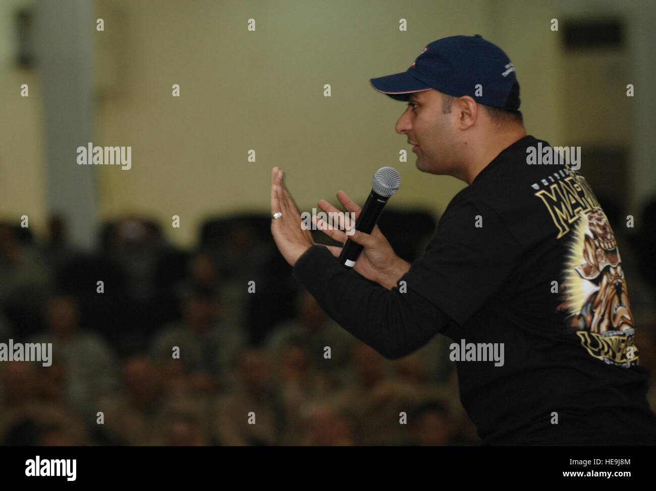 Comedian Russell Peters tells a joke during a USO show at Camp Fallujah, Iraq, Nov. 22, 2007. Peters traveled with Marine Corps Gen. James E. Cartwright, vice chairman of the Joint Chiefs of Staff, to visit troops for Thanksgiving.  Tech. Sgt. Adam M. Stump, U.S. Air Force. (Released) Stock Photo