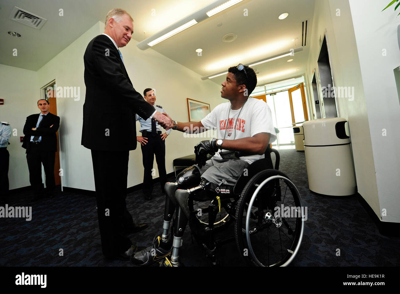 Deputy Secretary of Defense William J. Lynn III presents a coin to a wounded warrior during a visit to the Center for the Intrepid, Brooke Army Medical Center, San Antonio, Texas, Sept. 28, 2011.  Tech. Sgt. Jacob N. Bailey, U.S. Air Force) (Released) Stock Photo