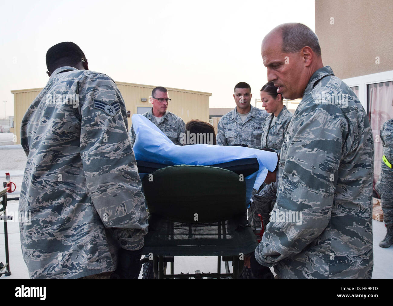 Lt. Col. Chris Hull, right, flight commander of the 379th Expeditionary Medical Group Enroute Patient Staging Facility, guides his medical team during the loading of a stretchered patient into an ambulance for evacuation July 18, 2016, at Al Udeid Air Base, Qatar. The team prepared 14 patients, including a military working dog, to be transported on a C-17 Globemaster III flight to U.S. military facilities in Germany. Technical Sgt. Carlos J. Treviño) Stock Photo